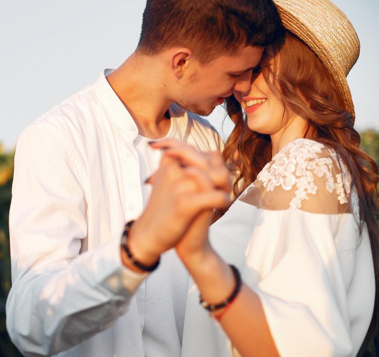 couple in sunny field holding hands