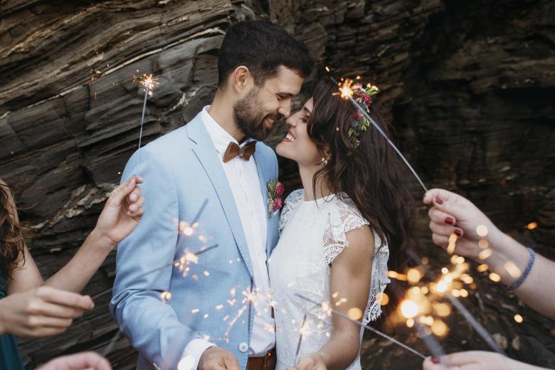 newly married couple on beach with sparklers 